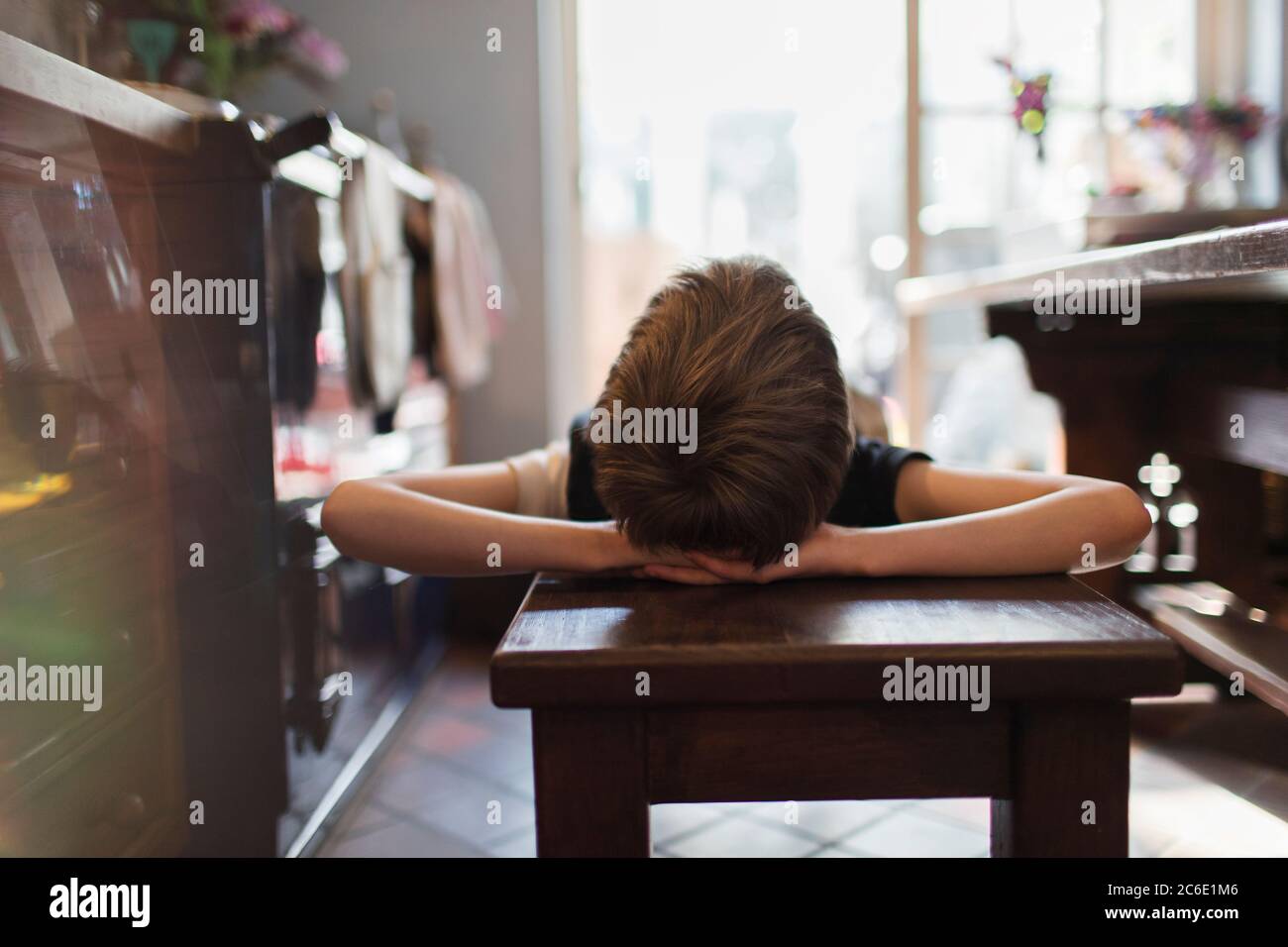 Boy relaxing on bench in kitchen Stock Photo