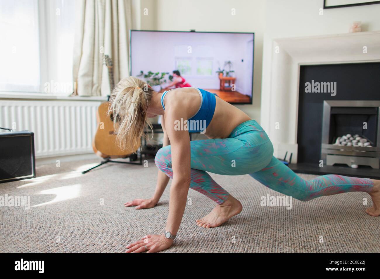 Woman practicing online yoga in living room Stock Photo