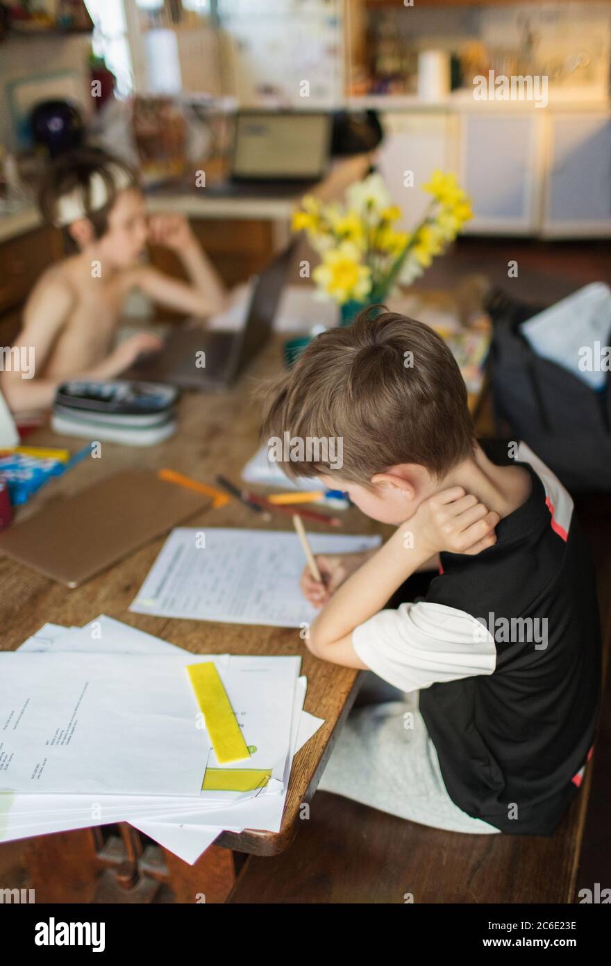 Brothers homeschooling at dining table Stock Photo - Alamy