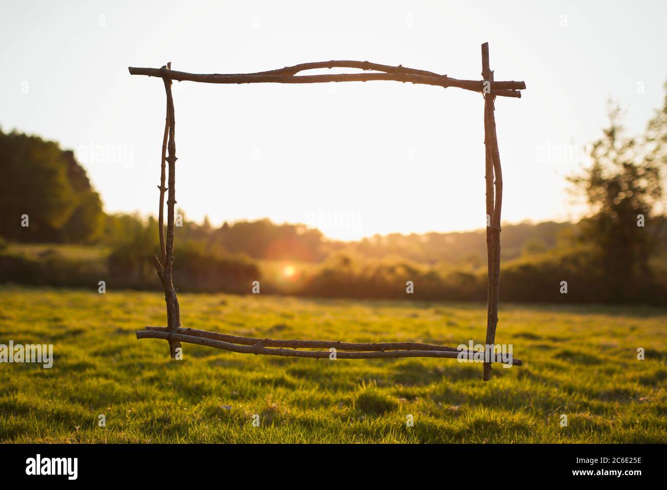 Wood stick frame overlooking sunny tranquil rural view Stock Photo
