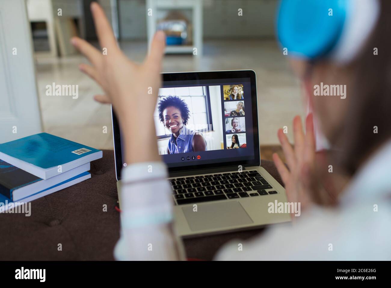 Woman video chatting with friends on laptop screen Stock Photo