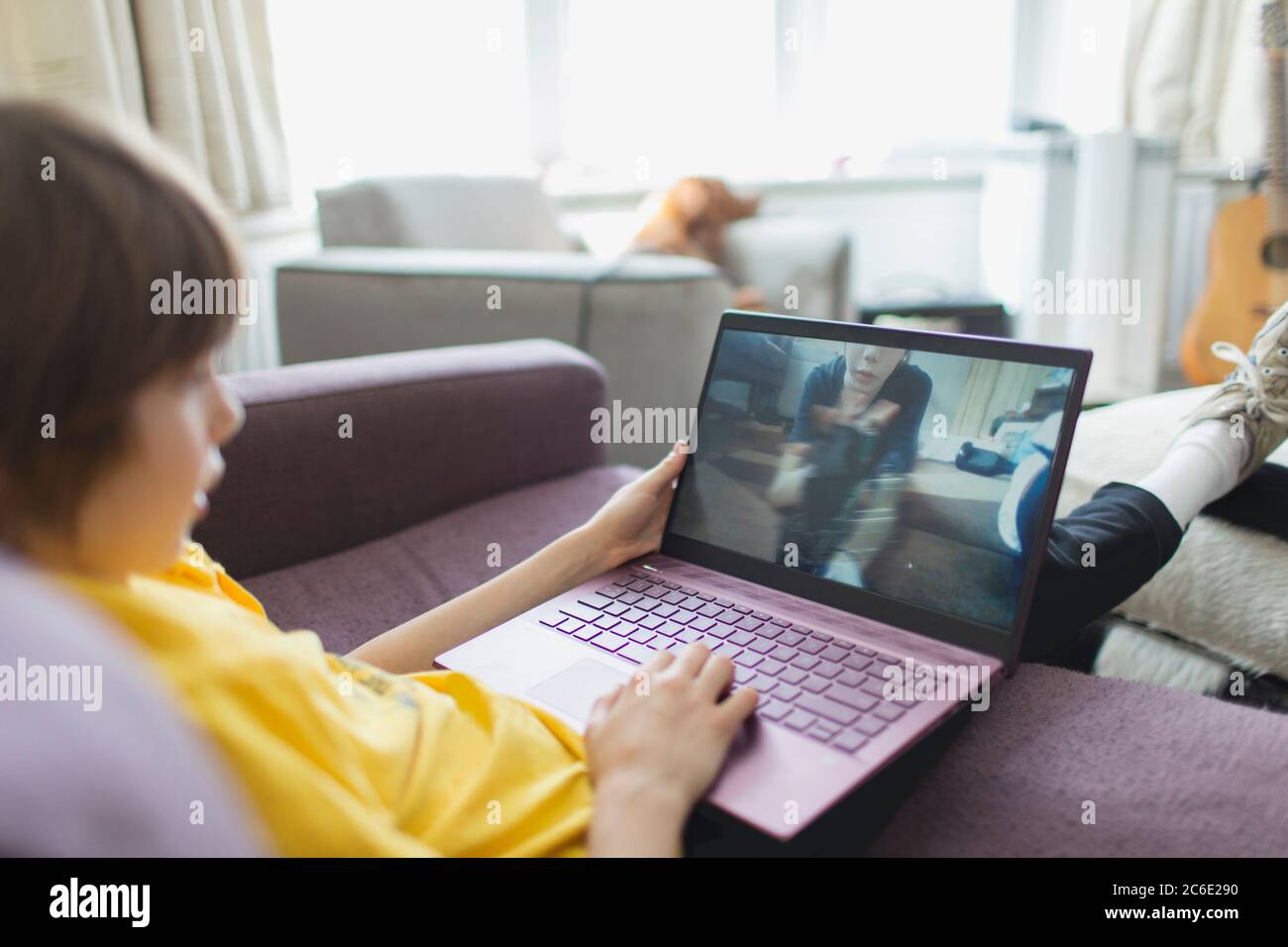 Boy video chatting with friend on laptop Stock Photo