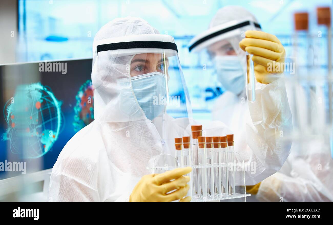 Scientists in clean suits researching coronavirus vaccine Stock Photo