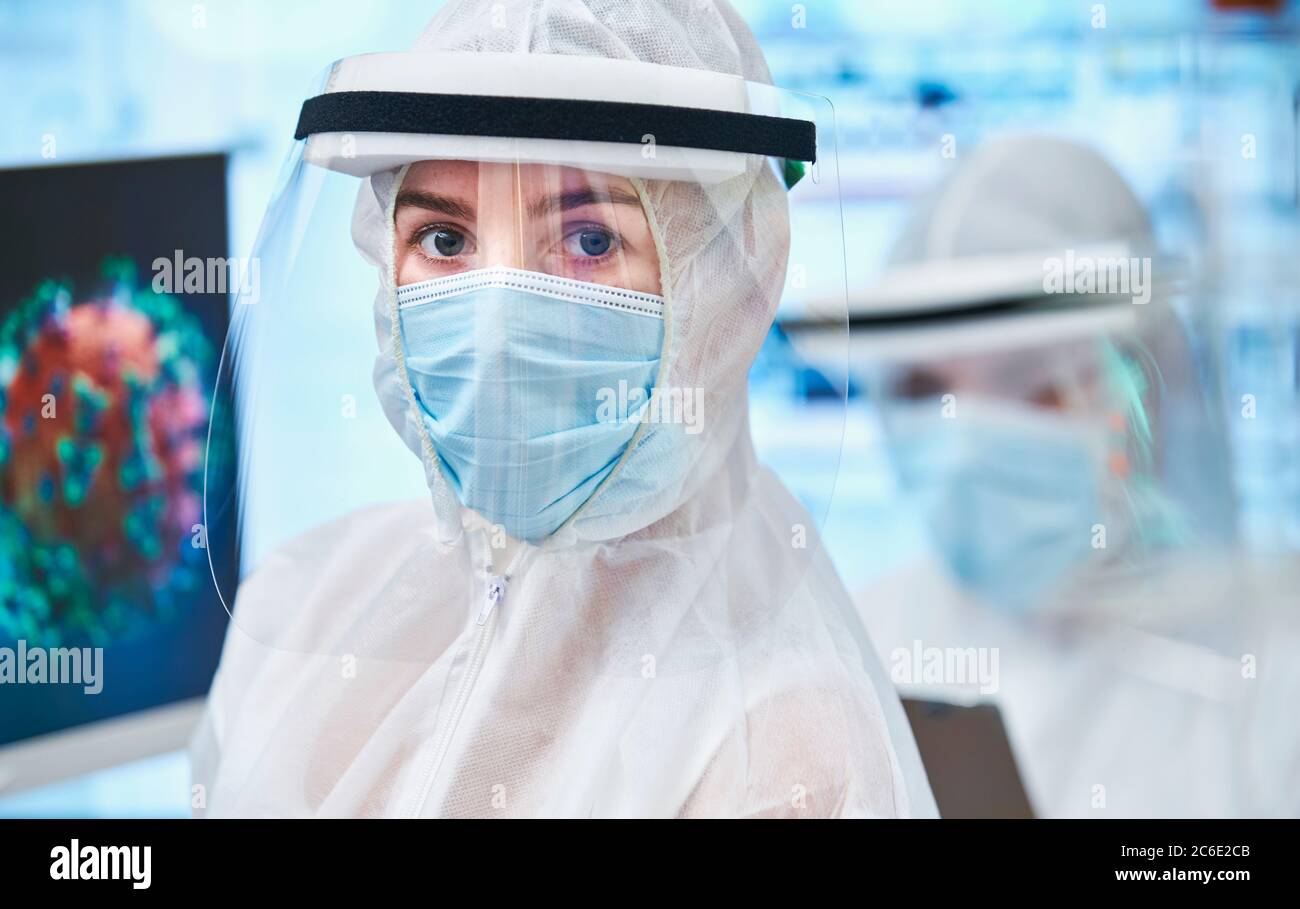 Portrait confident female scientist in clean suit studying coronavirus Stock Photo