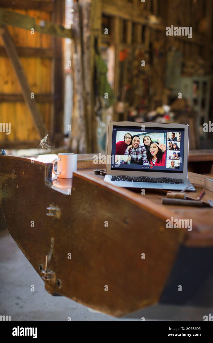 Friends video chatting on laptop screen on wooden boat Stock Photo