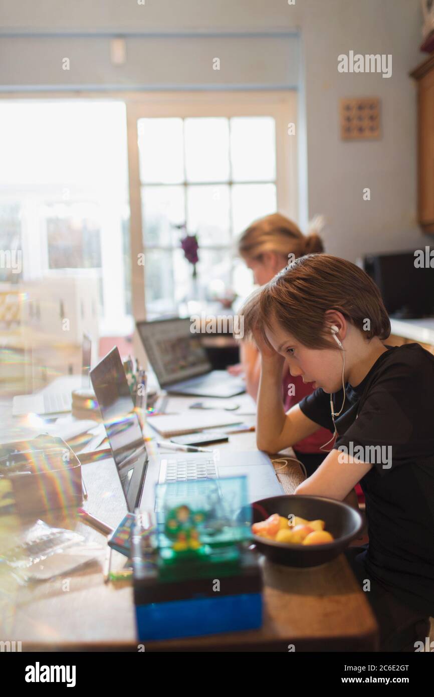 Boy homeschooling at laptop in dining room Stock Photo