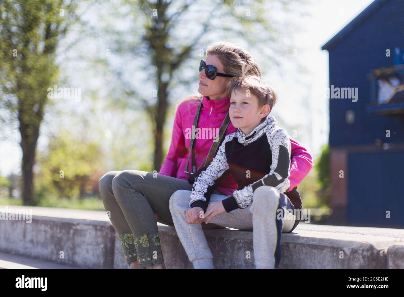 Affectionate mother and son on sunny ledge Stock Photo