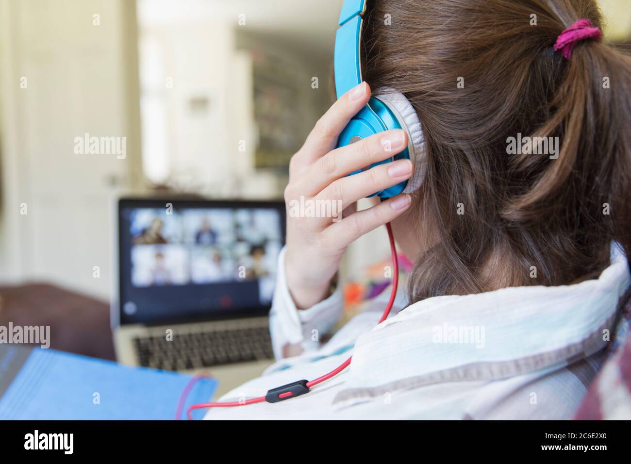 Teenage girl with headphones video chatting at laptop Stock Photo
