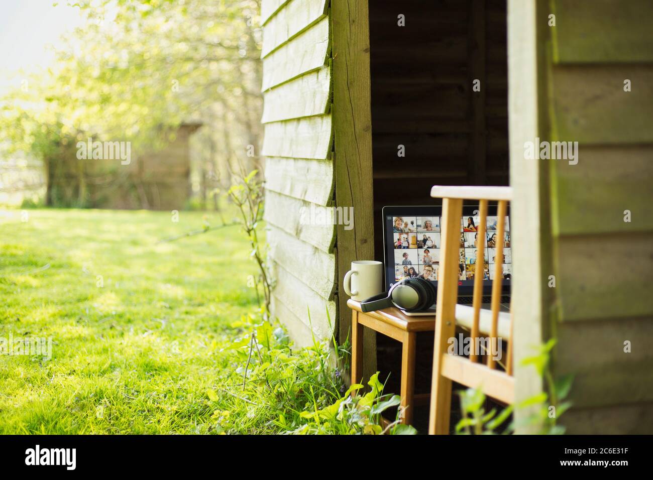 Friends video chatting on laptop screen in sunny garden shed Stock Photo