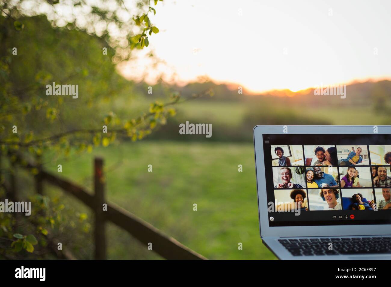Friends video chatting on laptop screen on rural fence Stock Photo