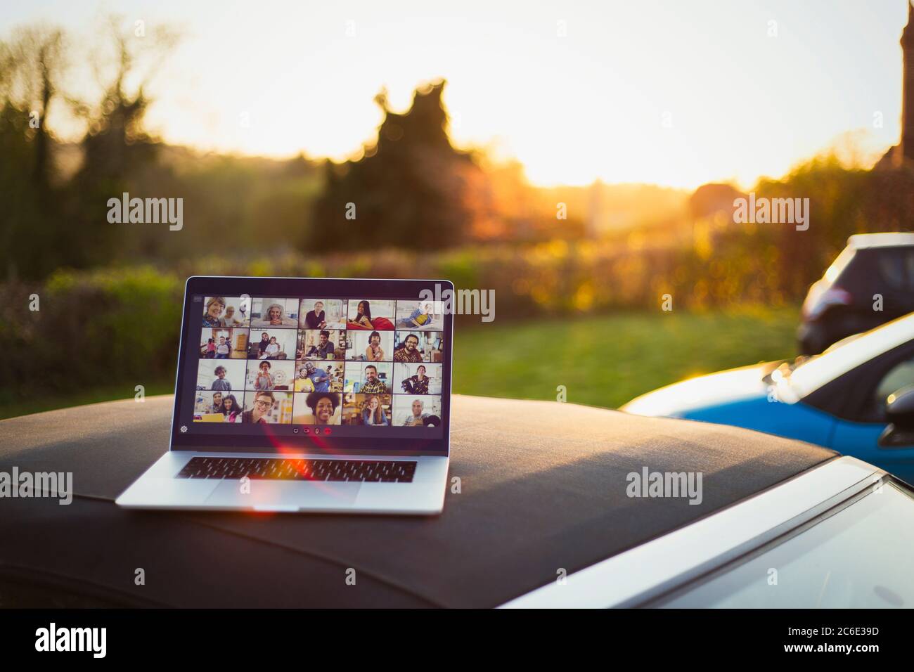 Friends video chatting on laptop screen on top of car Stock Photo