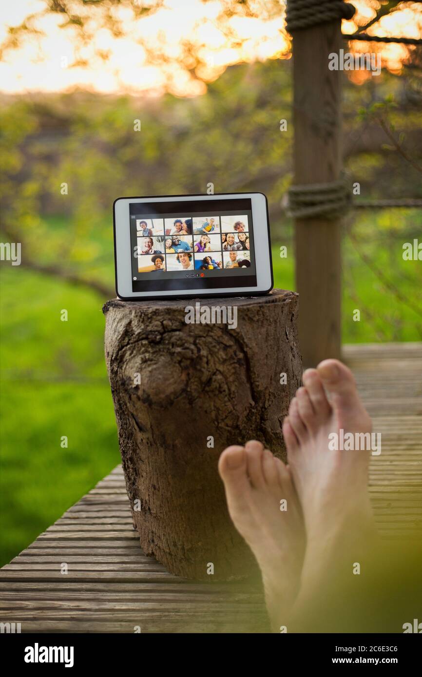 POV barefoot man video chatting with friends on digital tablet screen Stock Photo
