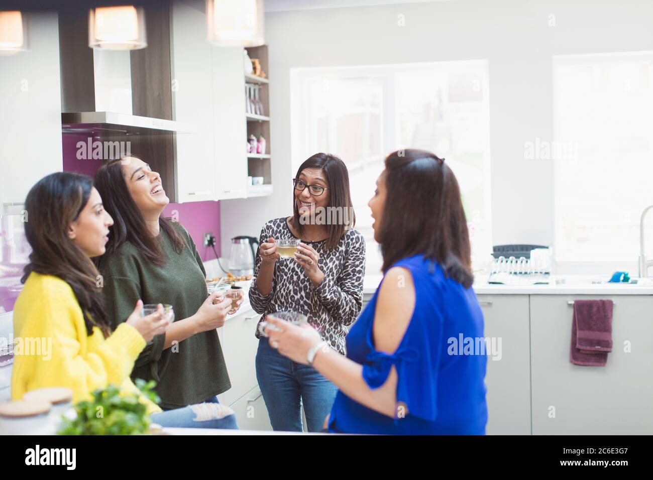 Women talking and drinking tea in kitchen Stock Photo