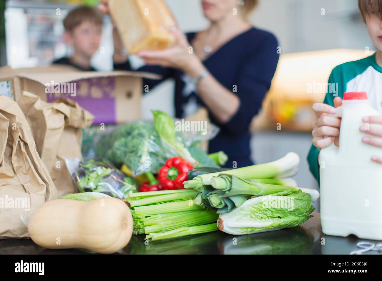Family unloading fresh produce in kitchen Stock Photo