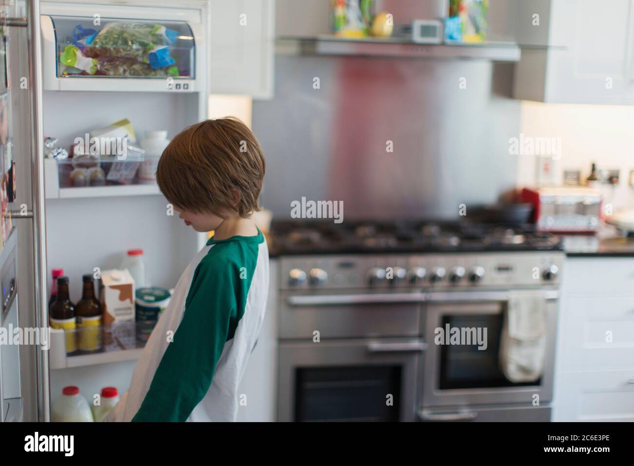 Boy looking inside kitchen refrigerator Stock Photo