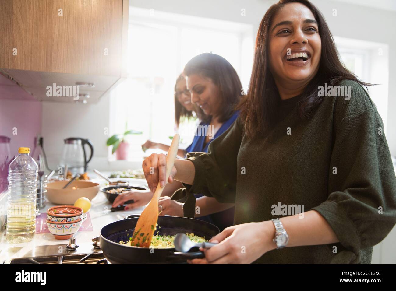 Happy Indian women cooking food in kitchen Stock Photo