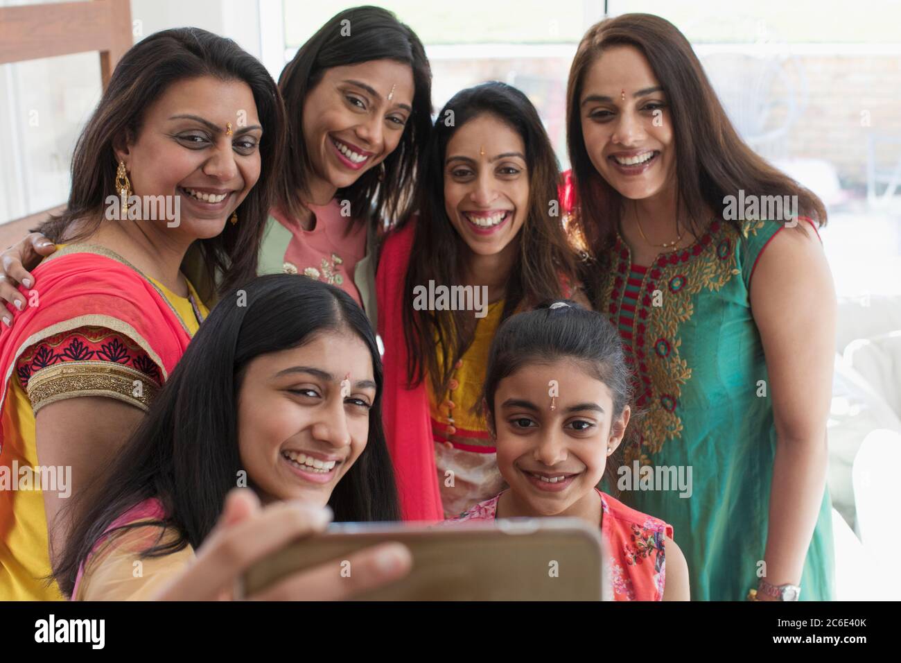 Happy Indian women and girls in saris taking selfie with smart phone Stock Photo