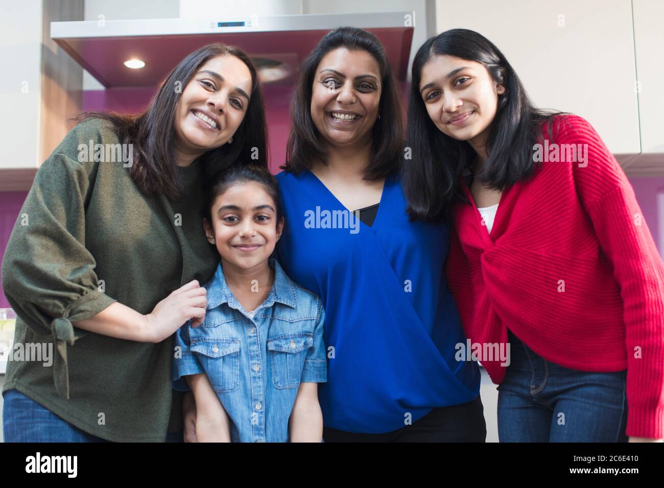 Portrait happy Indian mothers and daughters in kitchen Stock Photo