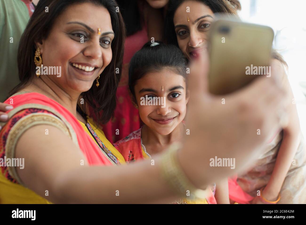 Happy Indian women in bindis and saris taking selfie with camera phone Stock Photo