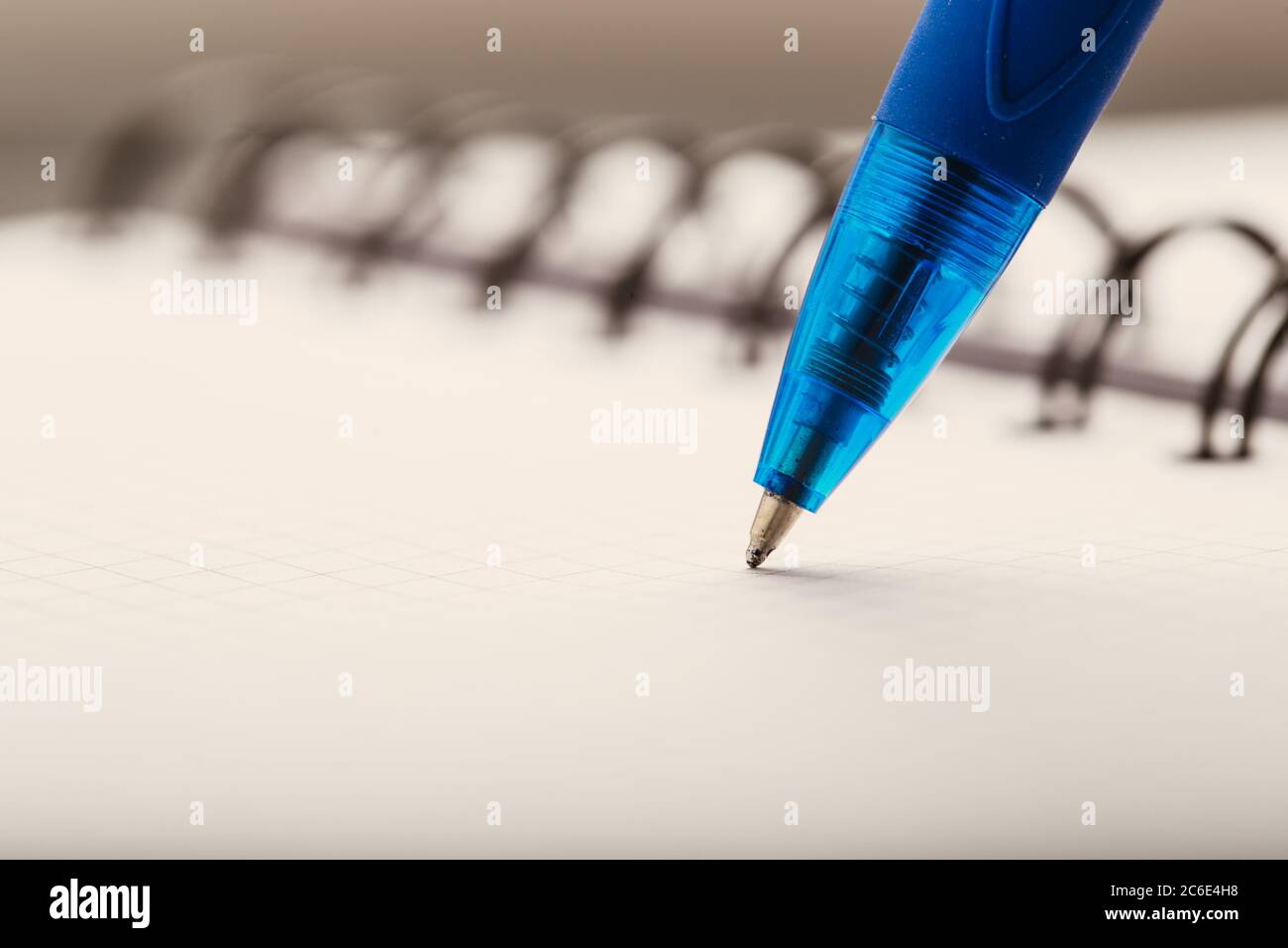 Opened notepad in a cage with an automatic plastic ballpoint pen close-up. Stock Photo