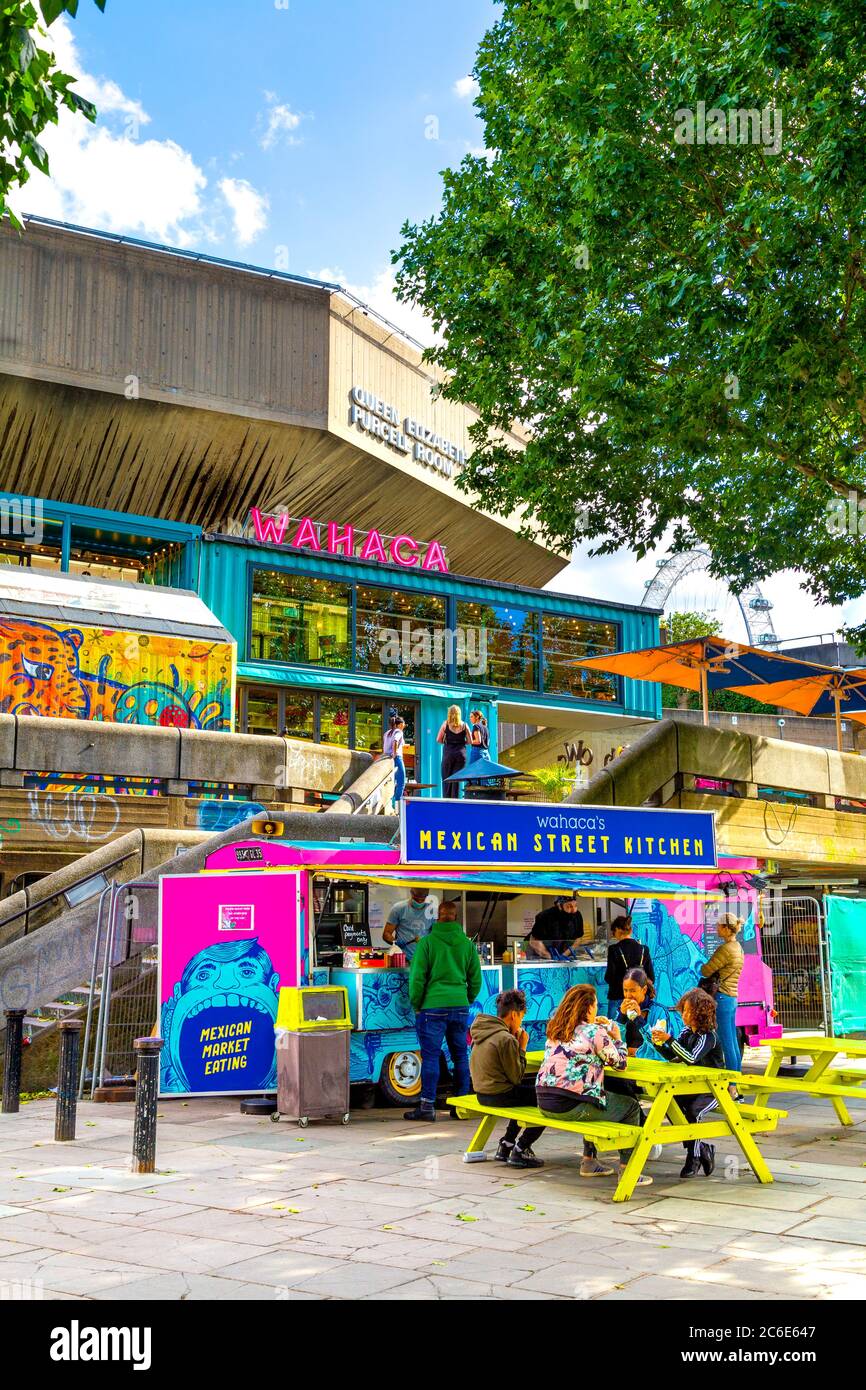 People eating outdoors at Wahaca restaurant Mexican food stall at the Southbank Centre Queen Elizabeth Hall building, Southbank, London, UK Stock Photo