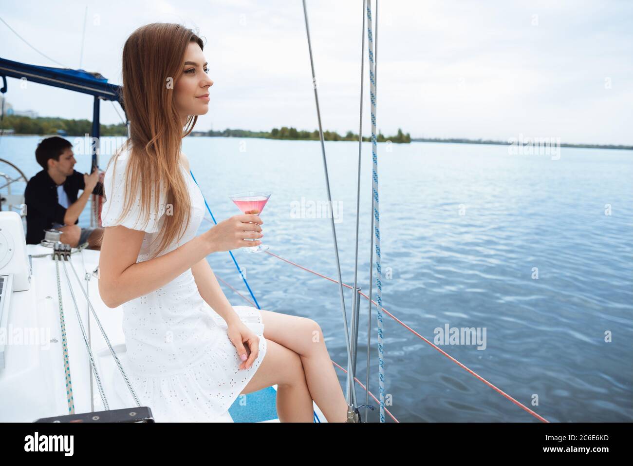 Happy couple drinking vodka cocktails at boat party outdoor, cheerful and happy. Young people
