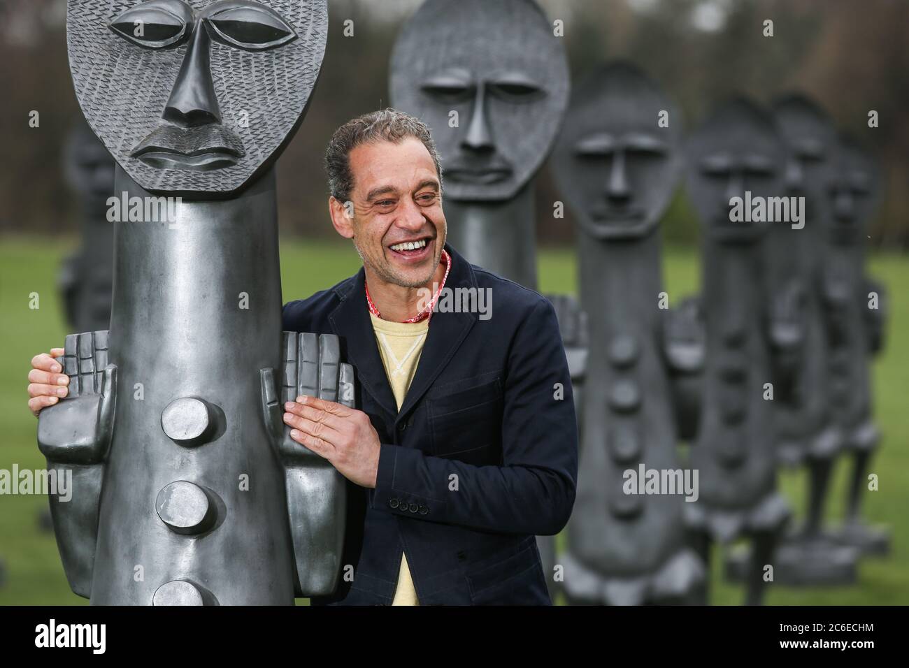 Artist Zak Ove in the middle of his 80 identical graphite figures at Yorkshire Sculpture Park in Wakefield, UK. The two metre tall sculptures are part Stock Photo
