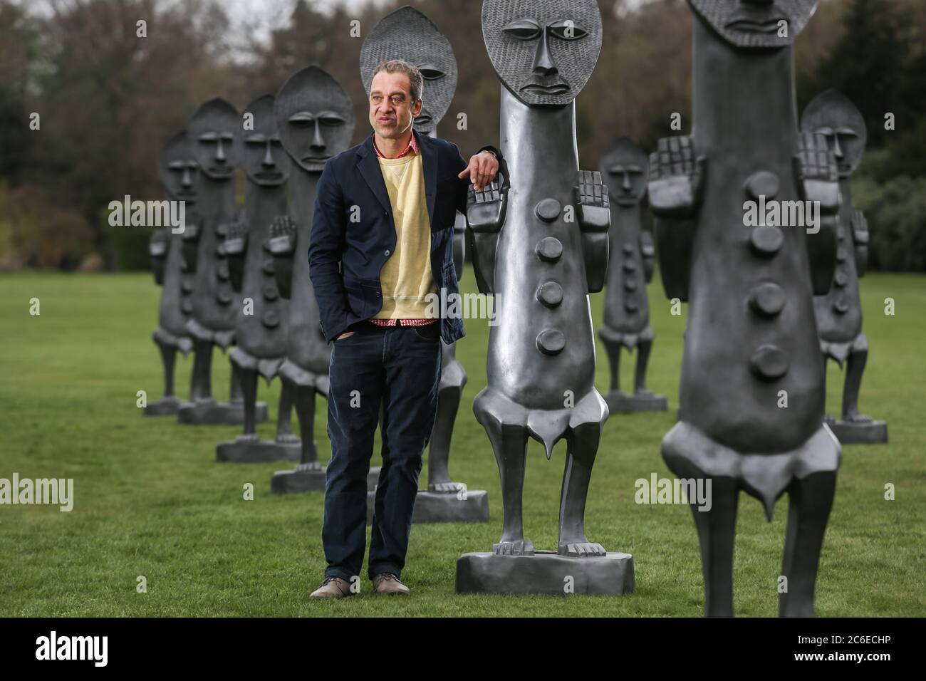 Artist Zak Ove in the middle of his 80 identical graphite figures at Yorkshire Sculpture Park in Wakefield, UK. The two metre tall sculptures are part Stock Photo