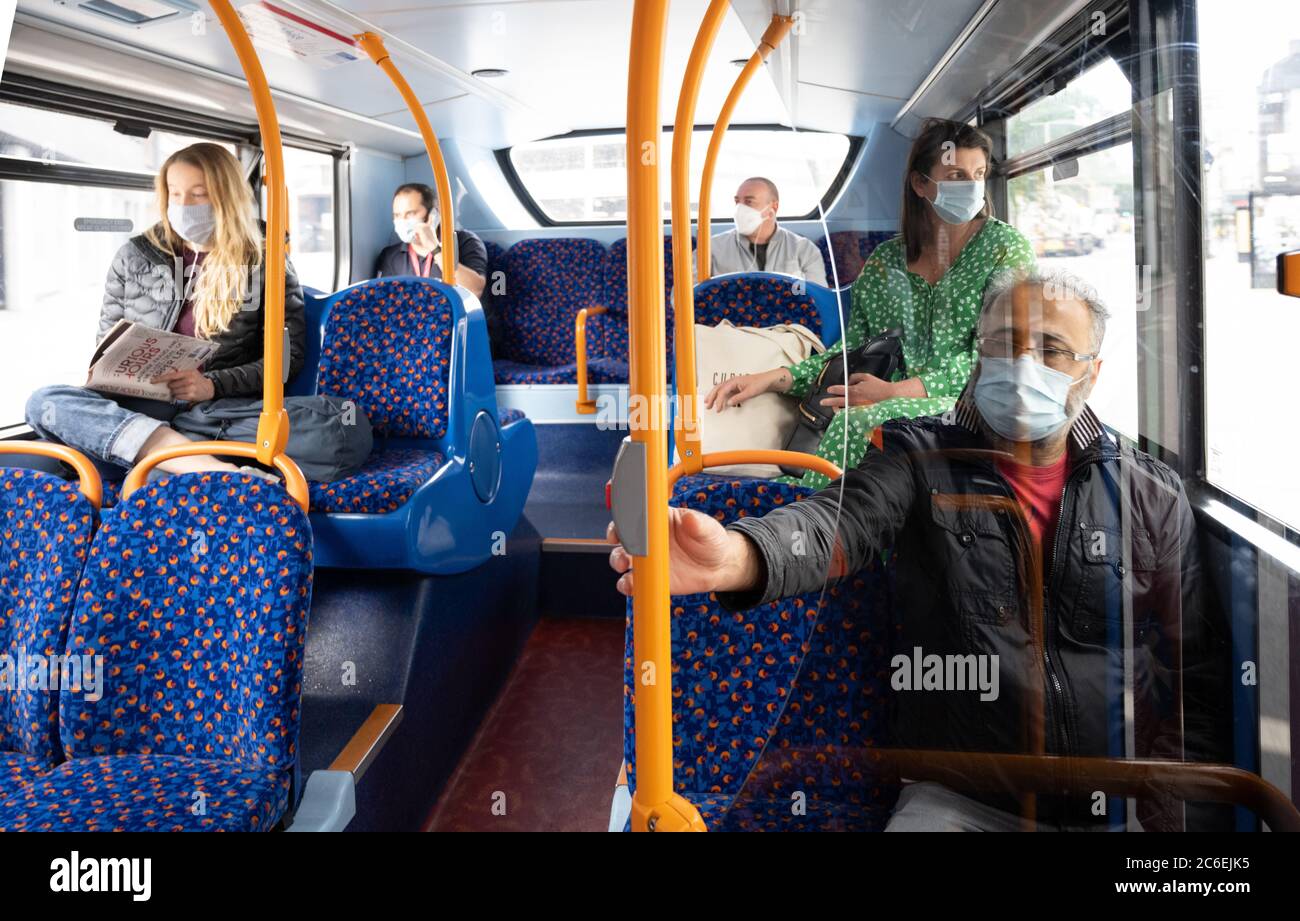 Commuters wearing face masks on London buses.  Route 205 bus to Bow Church.  July 6, 2020. London, UK.       (verbal agreement from everyone in photo) Stock Photo