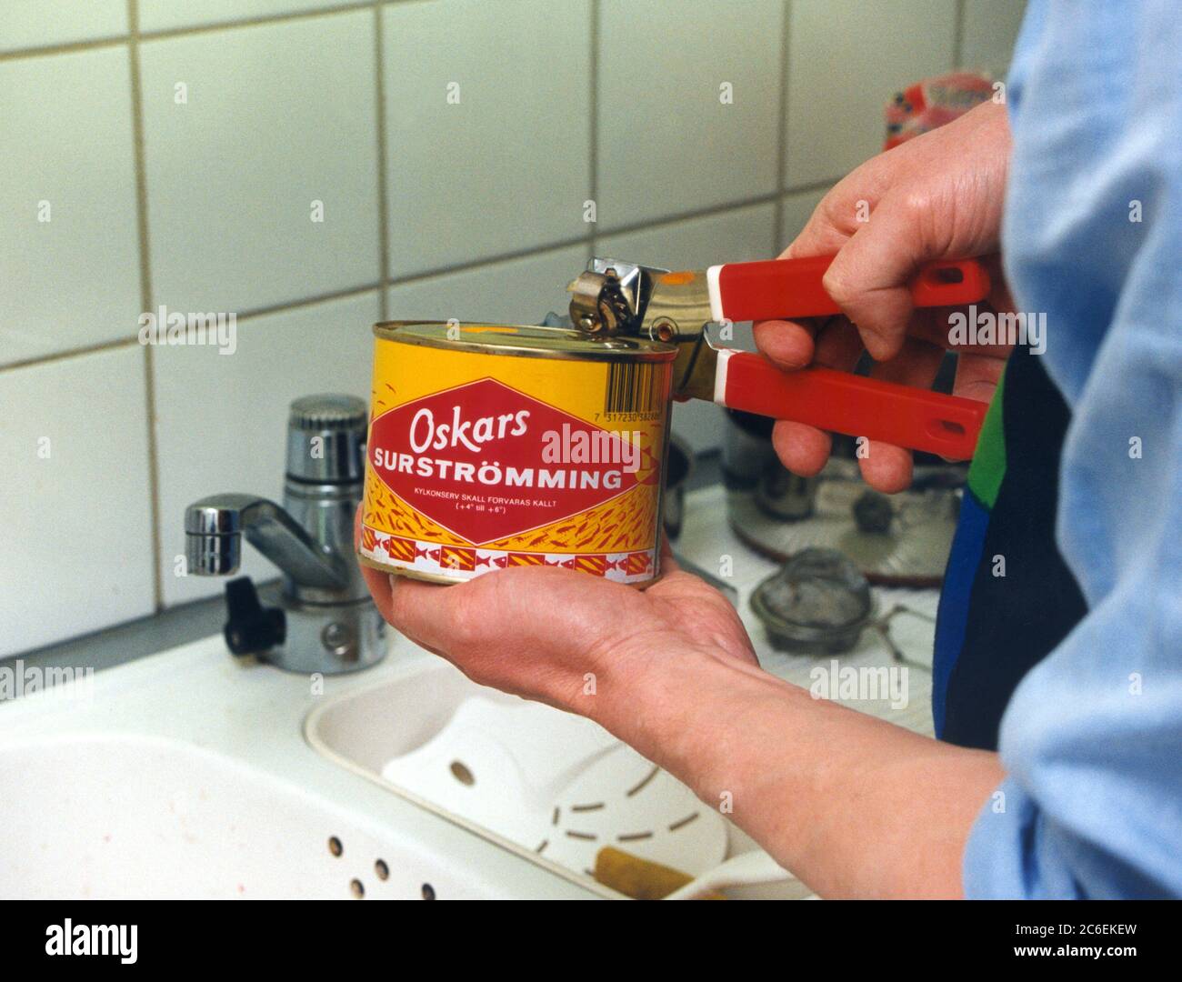 SURSTRÖMMING Sour Herring can is opened over the sink Stock Photo