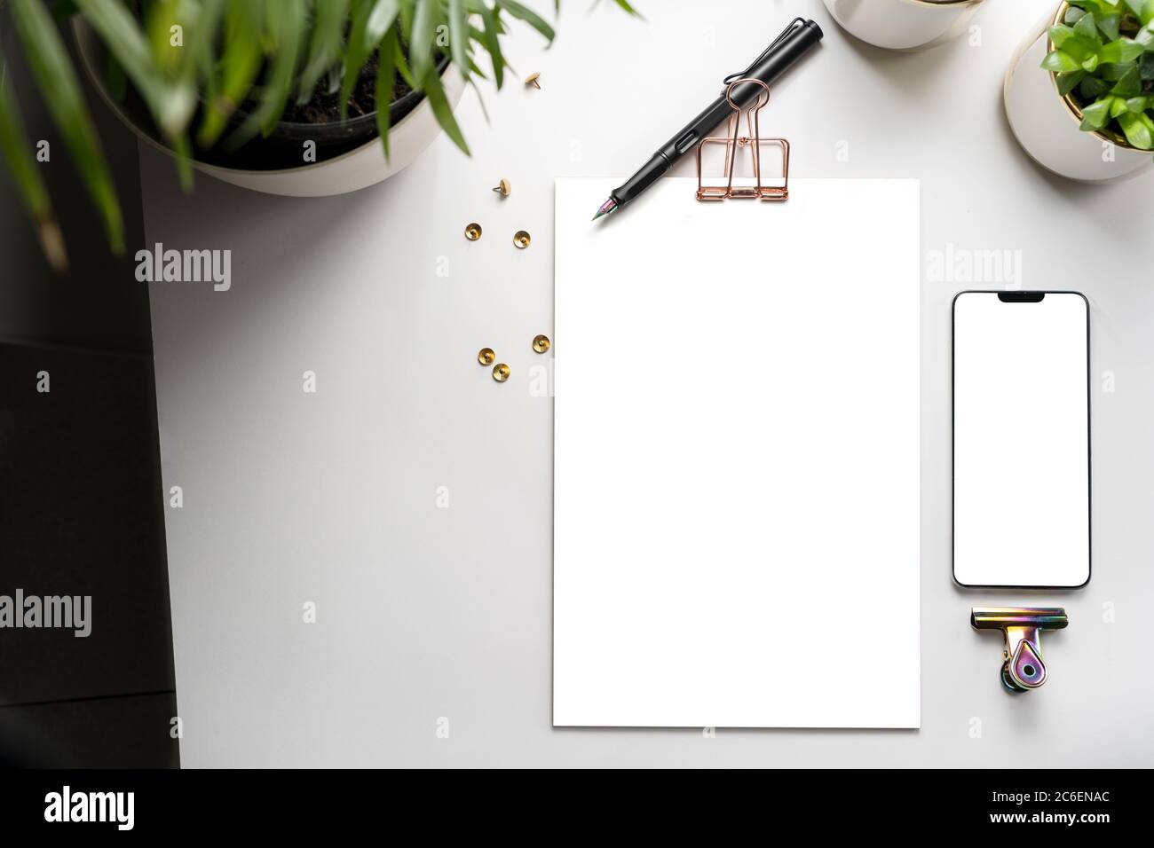 Top view clipboard and mobile template and green plants on the desk. branding mockup with workspace accessories Stock Photo