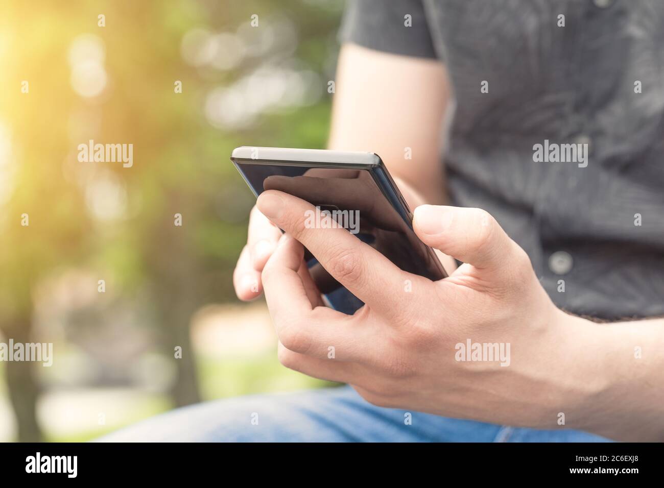 Man using mobile smart phone, close up. Young man holding mobile smart phone. Stock Photo