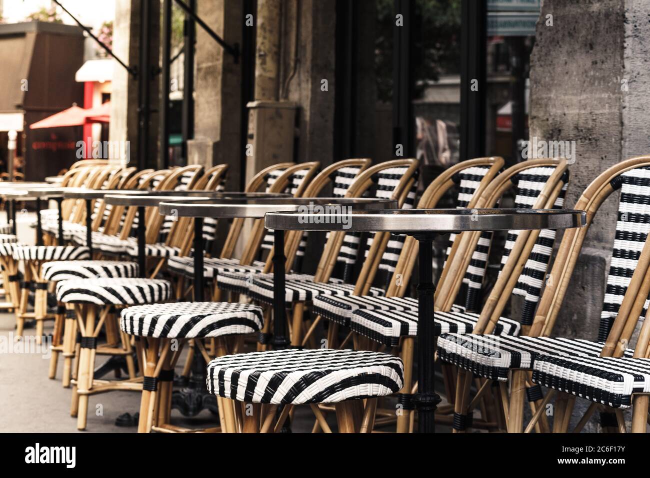 Parisian cafe with black and white chairs and tables lined up on the