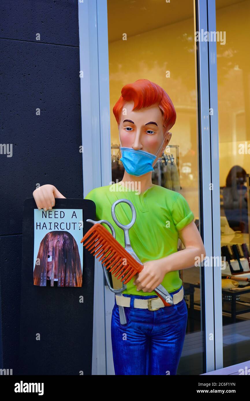 A display dummy wearing a face mask in front of a hairdresser shop in Old Town Düsseldorf during Corona crisis. Stock Photo