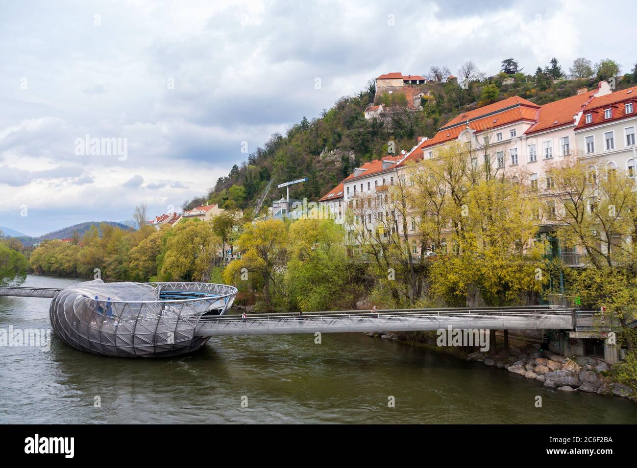 GRAZ, AUSTRIA - April 13 2012: The artificial island and bridge of a futuristic architecture style made of steel and glass on the Mur river in Graz. I Stock Photo