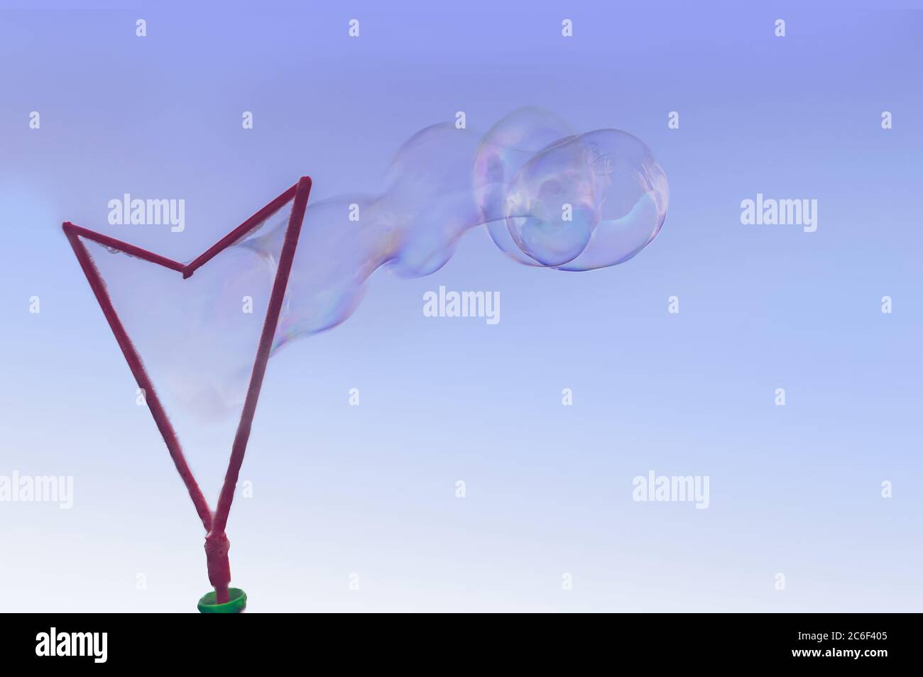 Blowing large soap bubbles using big plastic wand Stock Photo