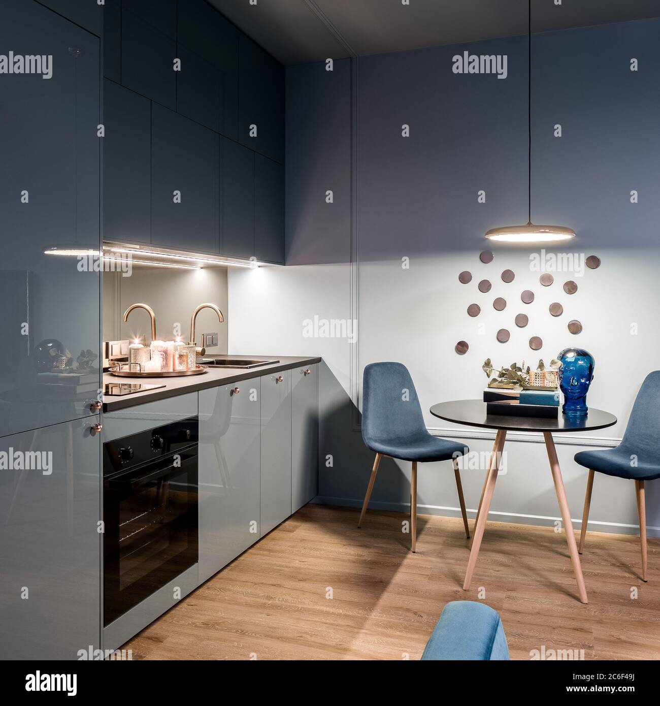 Elegant blue kitchen with modern dining area for two Stock Photo Alamy