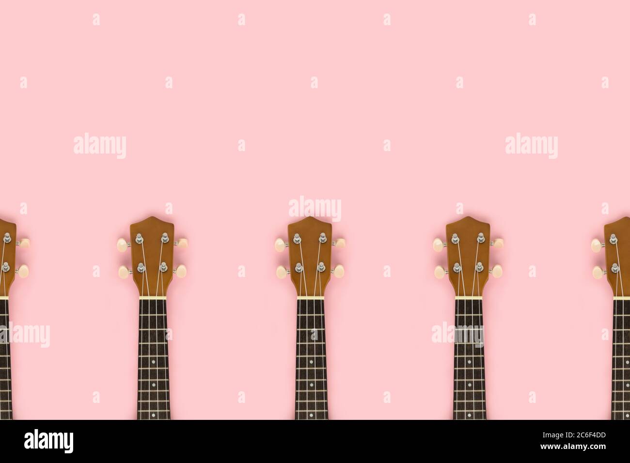Frame made of guitar fretboards on a pink pastel background. Musical