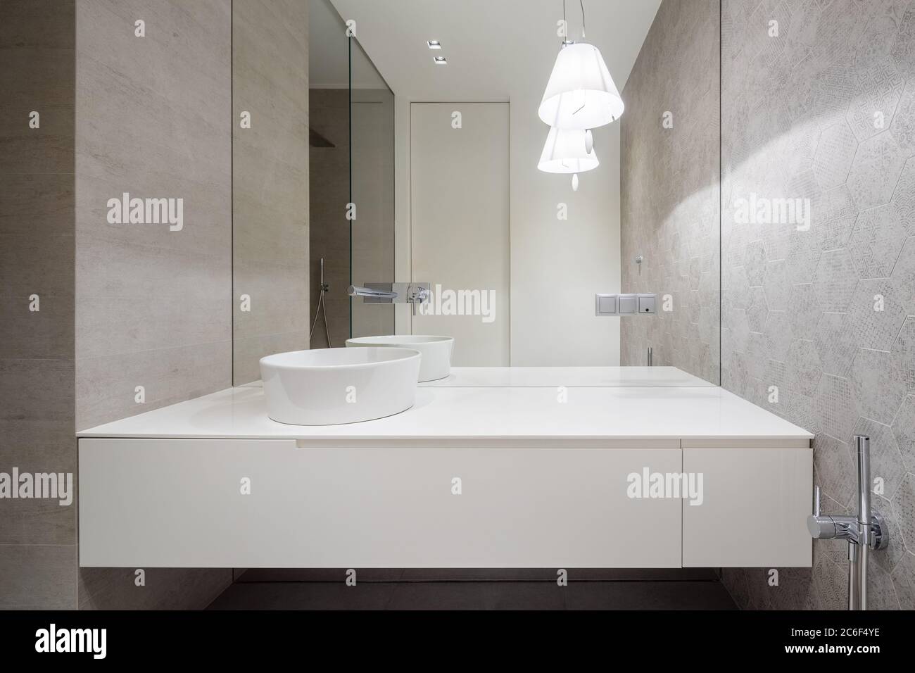 Minimalist bathroom with hexagonal tiles, big mirror and oval countertop basin Stock Photo