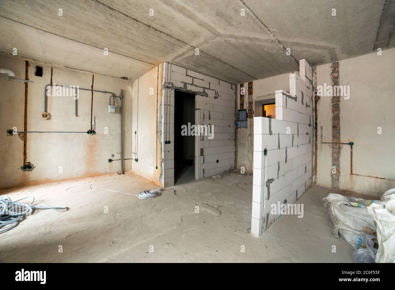 Interior of an apartment room with bare walls and ceiling under