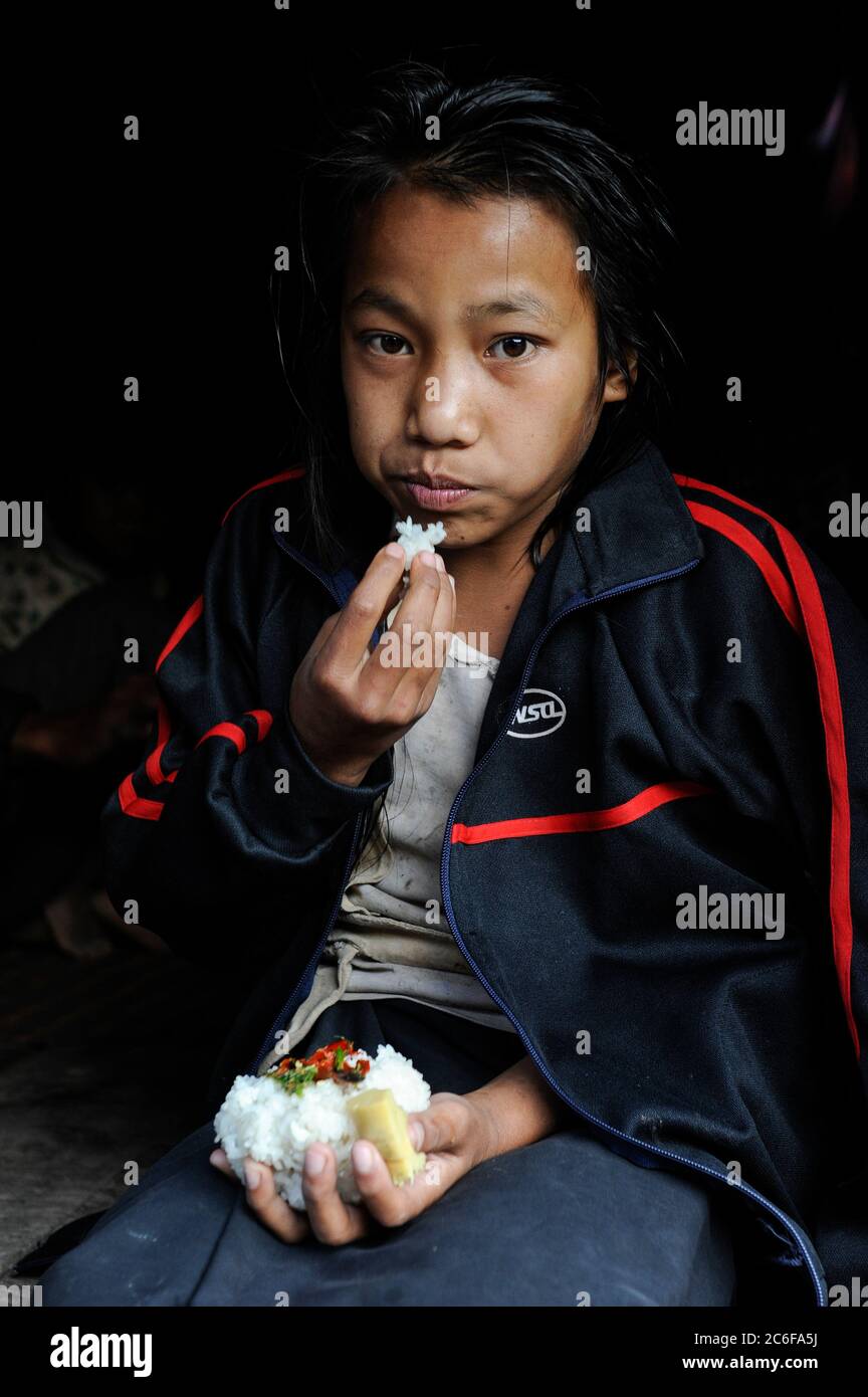 LAOS province Oudomxay , village Houyta, ethnic group Khmu, girl eats sticky rice / LAOS Provinz Oudomxay Dorf Houyta , Ethnie Khmu , Maedchen isst Klebreis Stock Photo