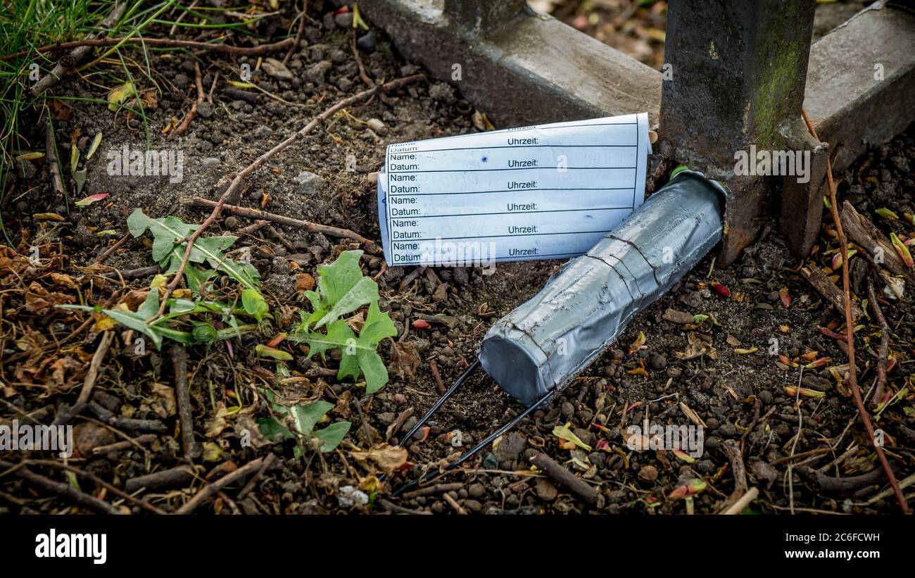 geocache container encased with duct tape and logbook hidden inside a  fence Stock Photo