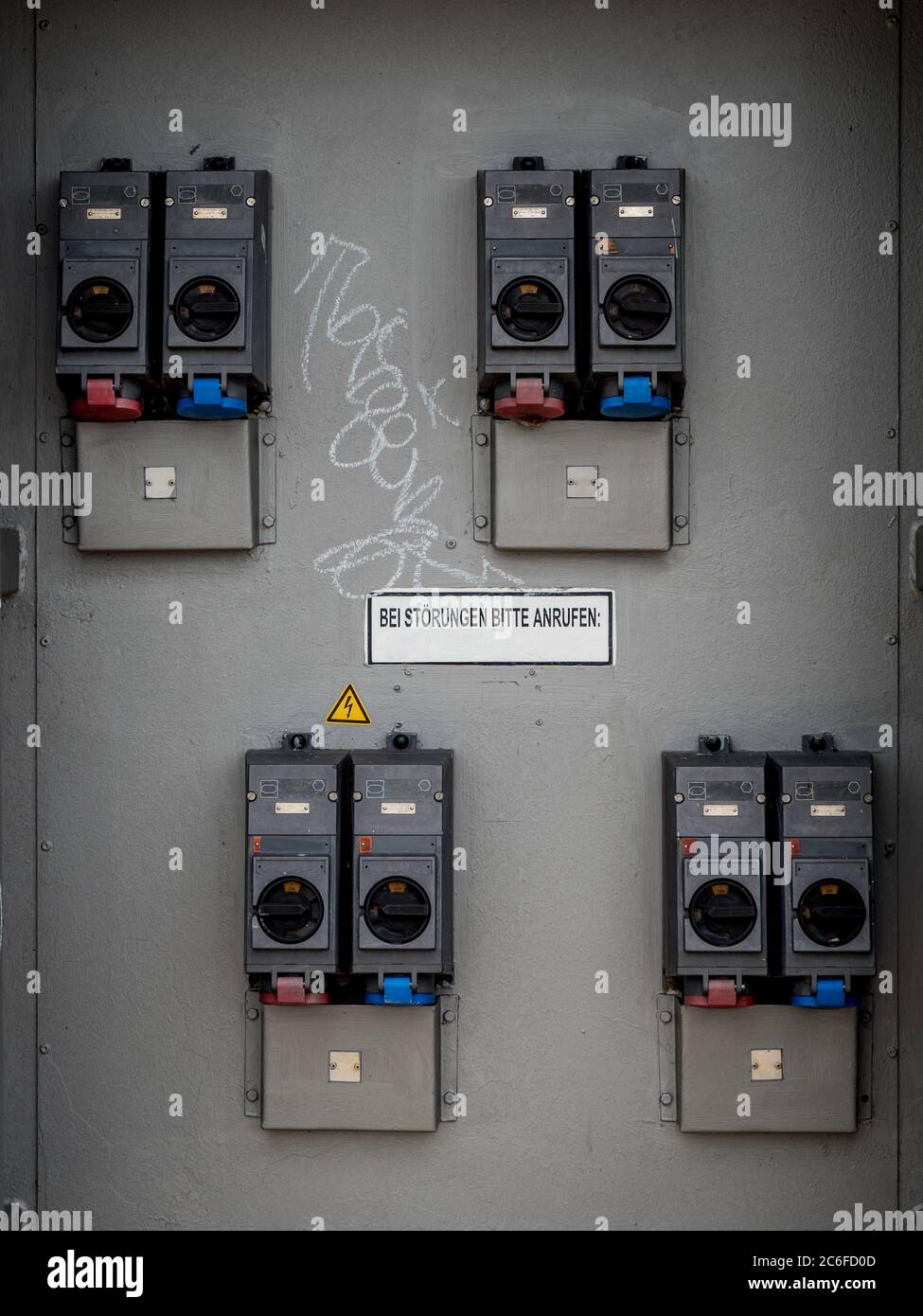 industrial high voltage switches with information sign, please call if there is a malfunction. bei stoerungen bitte anrufen in german language Stock Photo