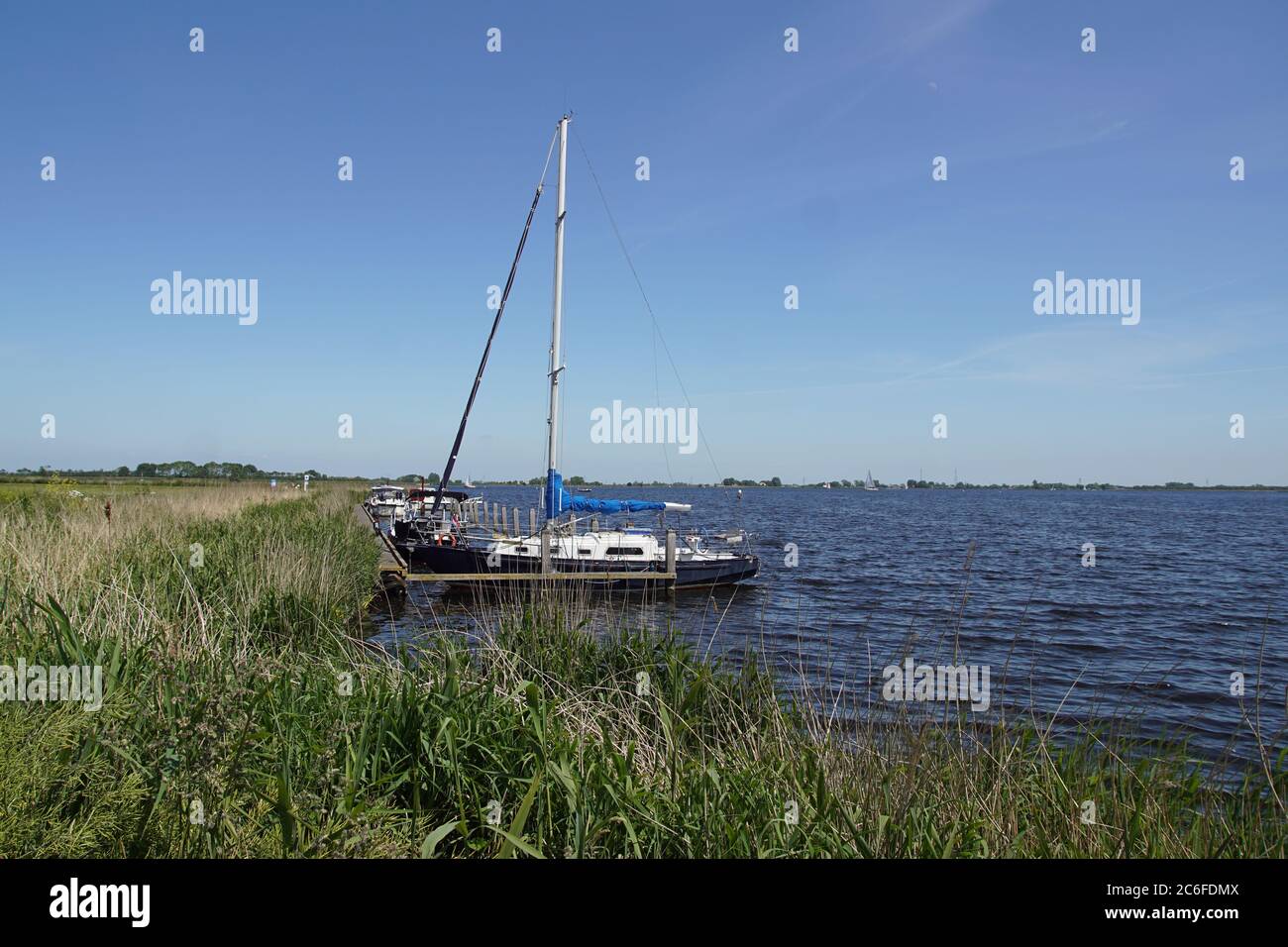 View on the Alkmaardermeer lake with a sailing ship near the Dutch village of Akersloot. May, Netherlands Stock Photo