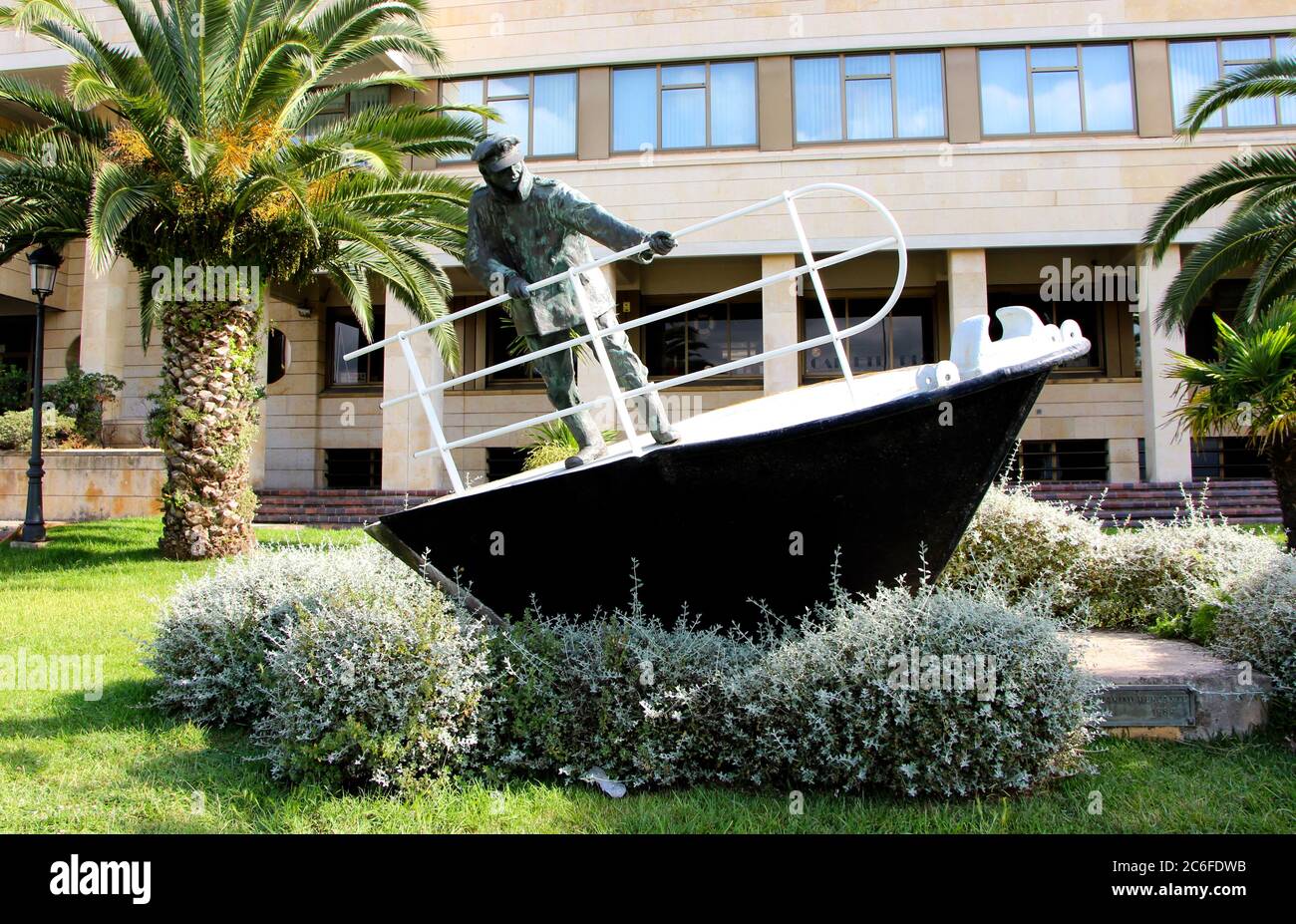 Sculpture of a merchant sailor standing at the bow of a boat holding onto the railing in rough seas outside the School of Marine Engineering Santander Stock Photo