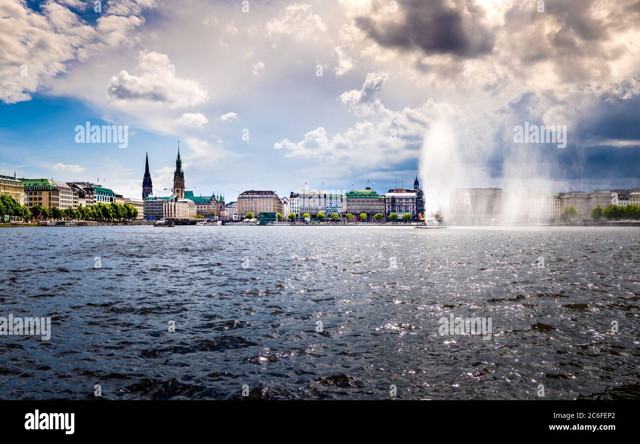 idyllic horizontal panorama of the binnenalster waterfront in hamburg old town with view to the jungfernstieg with town hall and st nicholas memorial Stock Photo