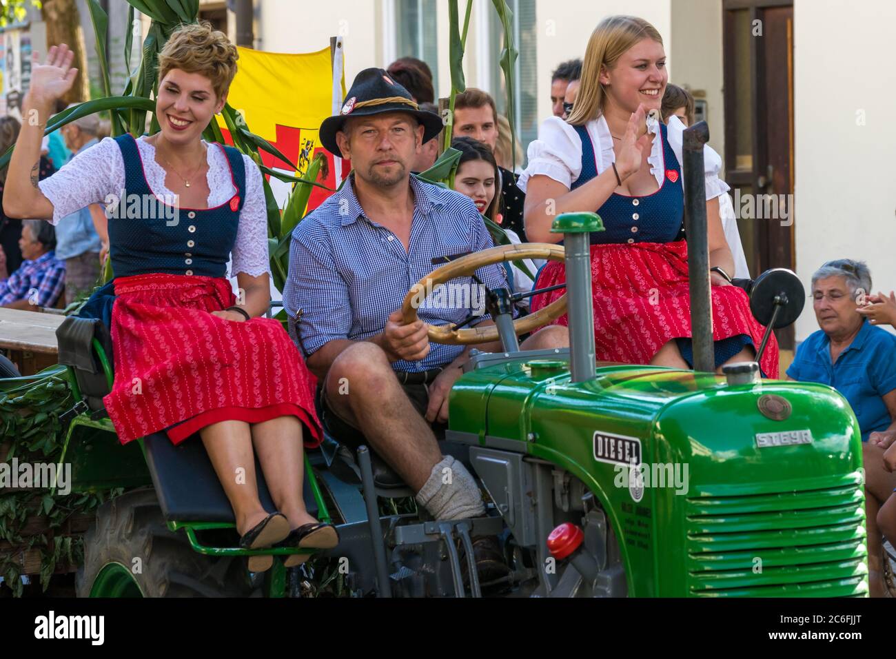 Villach, Austria - August 3th, 2019: Participants riding a tractor at the Villacher Kirchtag, the largest traditional festival in Austria Stock Photo