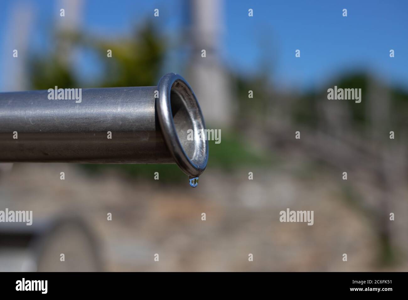 closeup of the last drop of water coming out a pipe simbolyzing draught, hot weather and climate change Stock Photo