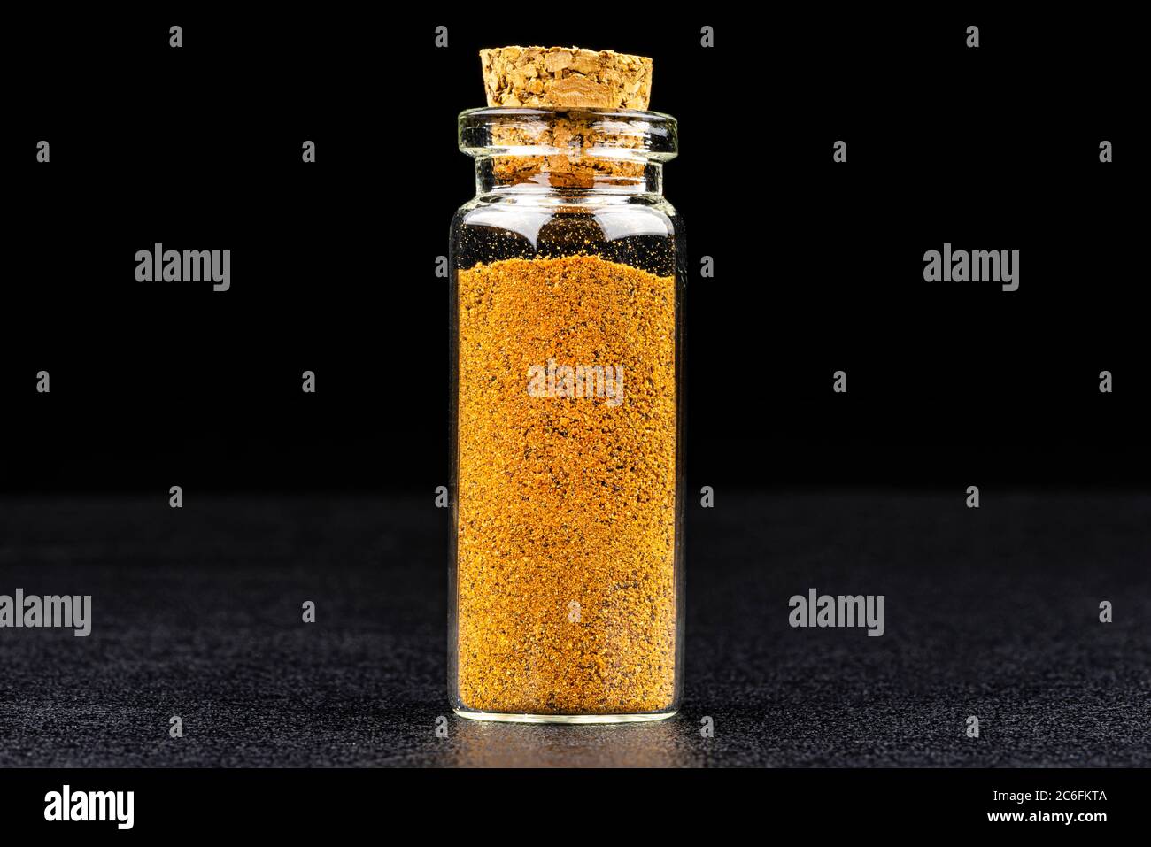 Macro shot of nutmeg spice in a small glass bottle closed with a cork,  isolated on a black background Stock Photo - Alamy