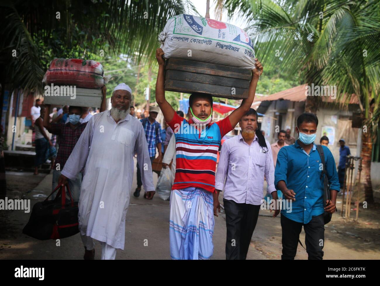 Dhaka, Bangladesh. 9th July, 2020. Workers leaving the Latif Bawany Jute mill with their luggage as state-owned jute mill employees are laid off.The government has decided to send 25,000 workers of state-owned jute mills into early voluntary retirement in a bid to curb the losses incurred over the past years. The workers will be sent into retirement through the golden handshake scheme, the provision in an employment agreement that states that the employer will provide a significant severance package if the employee is laid off. Credit: Sultan Mahmud Mukut/SOPA Images/ZUMA Wire/Alamy Live News Stock Photo